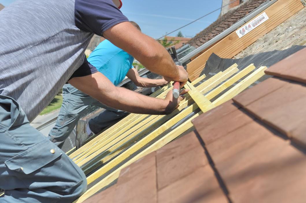 Workers installing wooden beams on roof.
