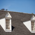 A roof with two windows and a sky background