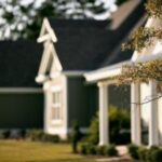 Suburban houses with trees and green lawn.