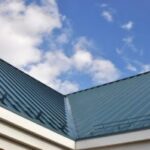 Blue metal roof against cloudy sky.