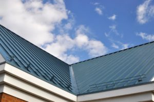 Blue metal roof against cloudy sky.