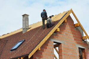 Workers repairing roof of a house.