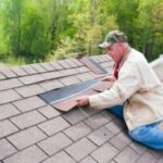 Man repairing roof with shingles.