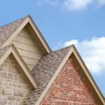 A close up of the corner of a house with sky in background