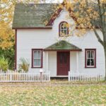 A white house with red door and shutters.