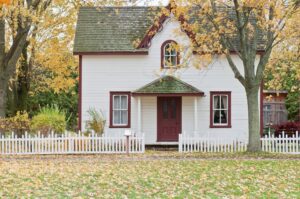 White house with picket fence in autumn.