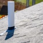 Shingled roof with a white vent pipe.