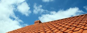 Red tiled roof under blue sky.