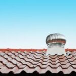 Red tiled roof with metal ventilation turbine.