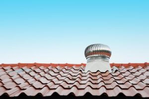 Red tiled roof with metal ventilation turbine.