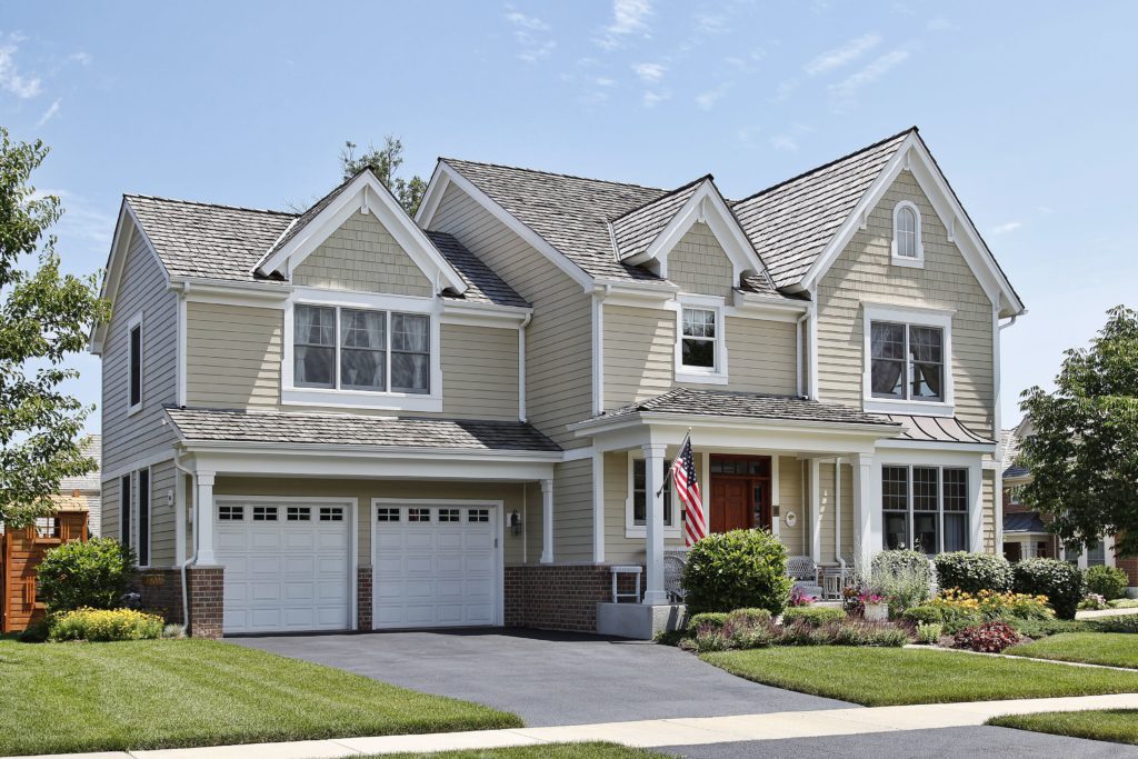 Elegant two-story suburban house with a manicured lawn and double garage.