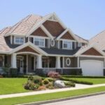 Large suburban house with a manicured lawn and driveway.