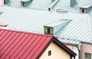 Close-up of rooftops with different colored metal sheets and a small window.