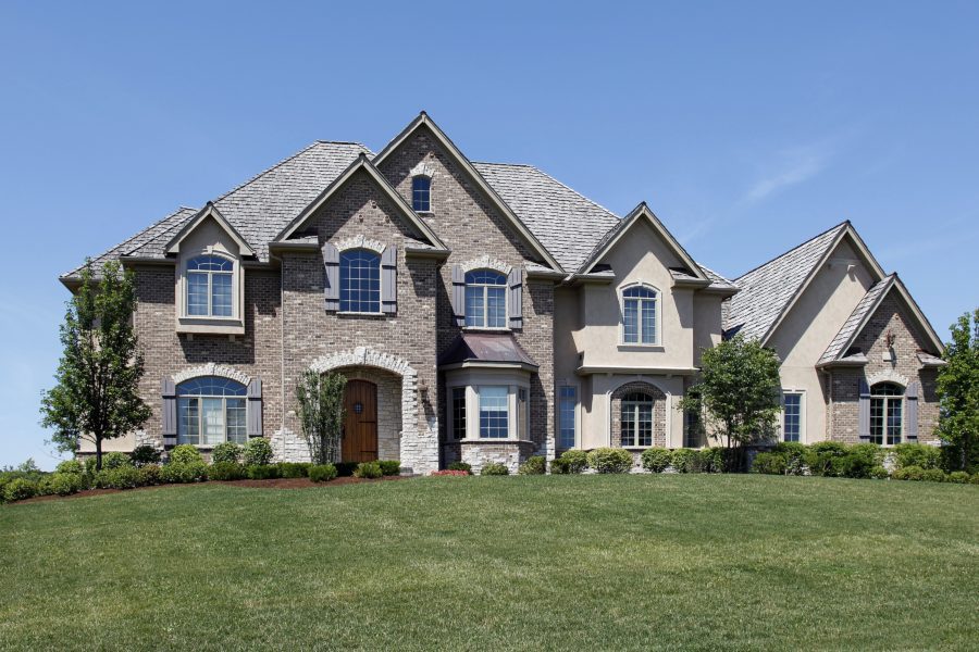 Large two-story suburban house with stone and stucco exterior.