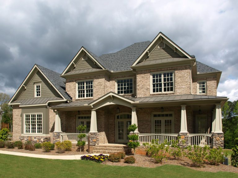 Large suburban house with a stone porch and multiple gables.