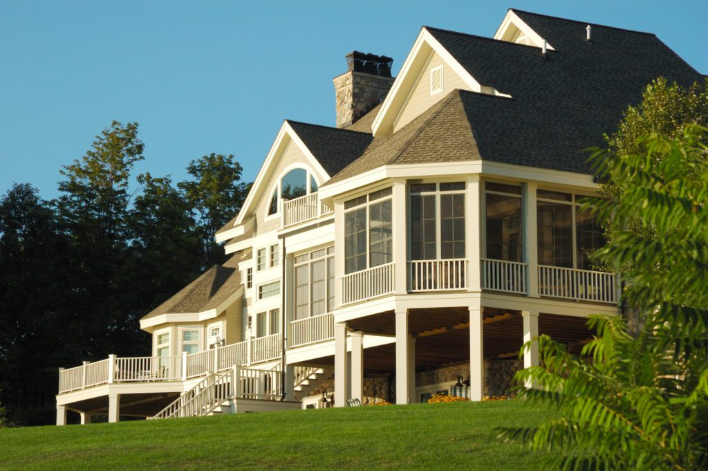 Large house with wrap-around porch on a sunny day.