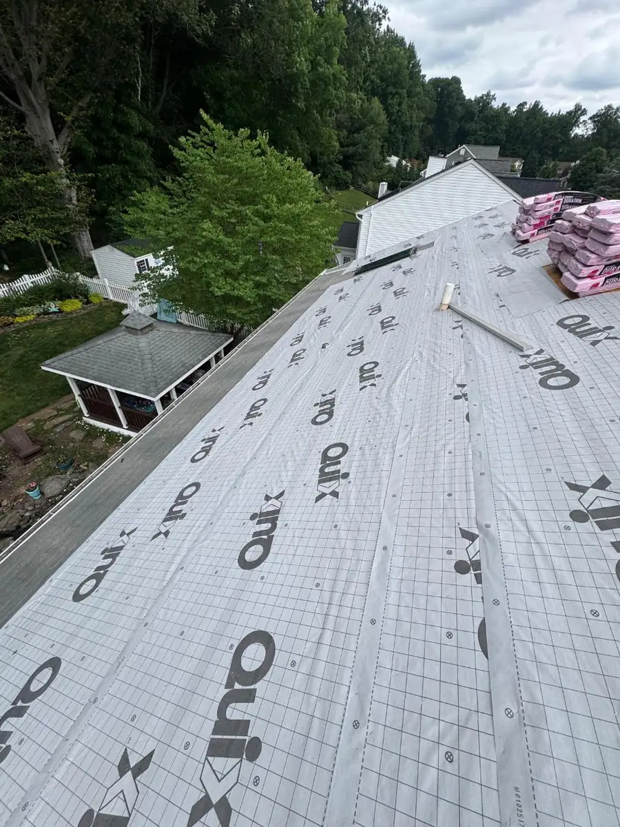 Roof underlayment installed and GAF Timberline shingles staged for installation